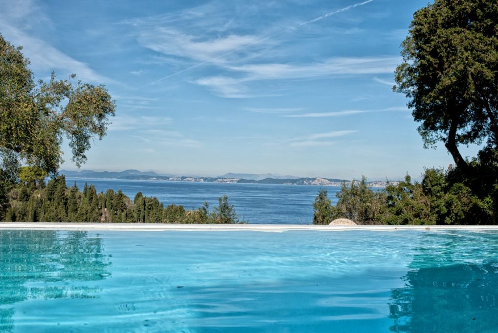 The infinity pool at Mistral House meeting the deep blue Ionian Sea and the Paxos coastline beyond